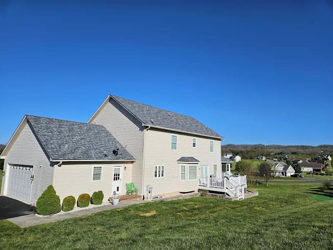 Beige two-story home with a gray asphalt shingle roof