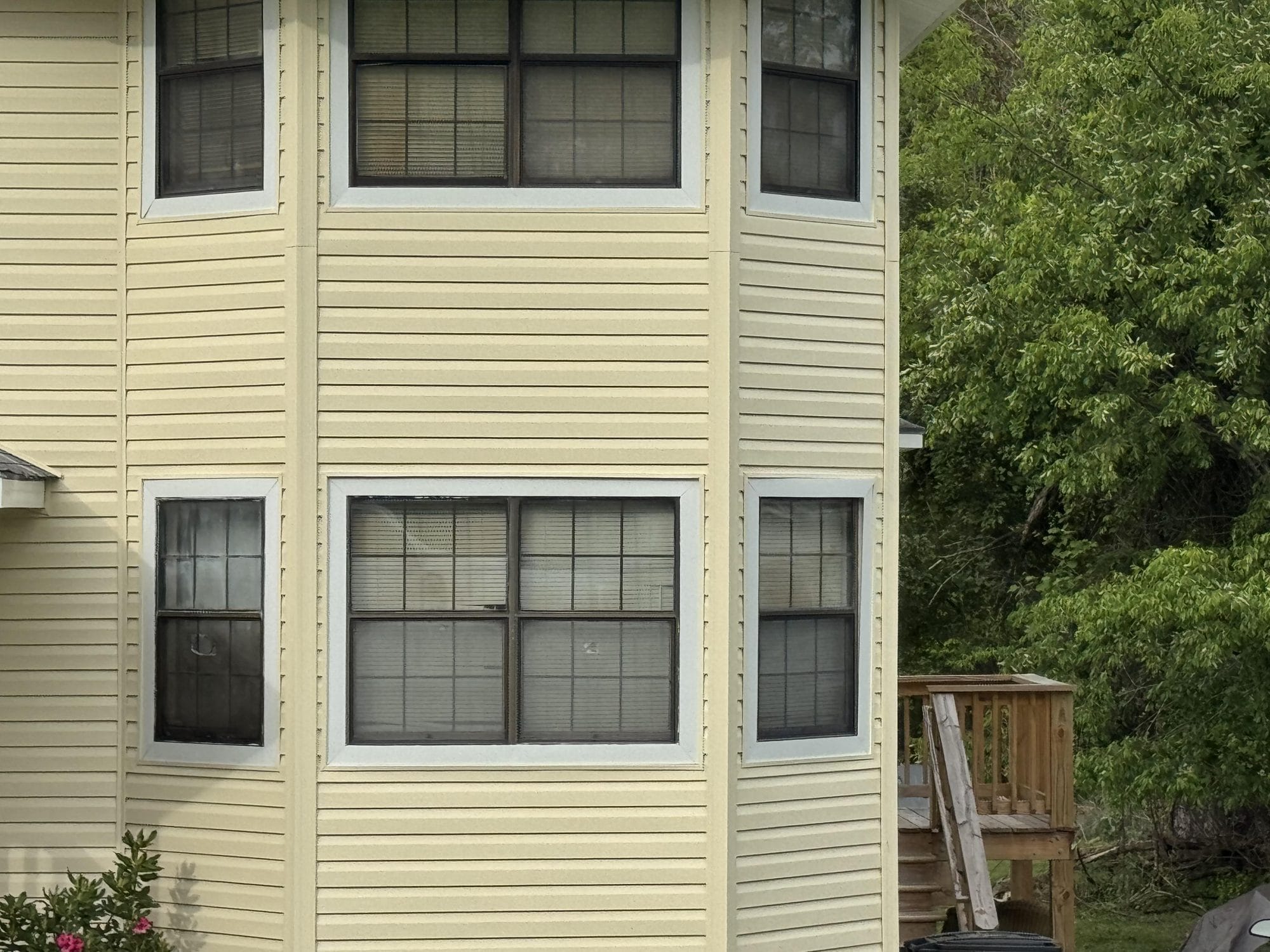 Cream vinyl siding installed on a home with a bay window